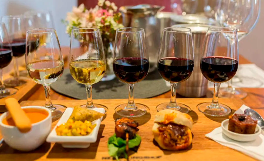 Copa de vino tinto y blanco acompañando distintos platos de comida.